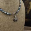 A necklace with pearls and a silver charm.