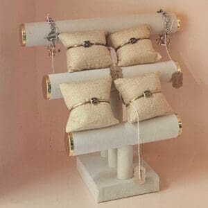 A white stand with eight pillows hanging from it.