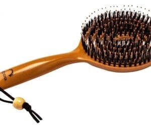 A wooden brush with a small hair comb on top of it.